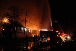 "The building is fully involved from one end to the other where two families once lived happily," says photographer Lew Watters.